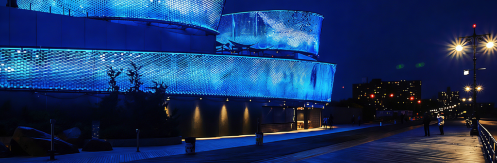 Night view of a Kinetic Wind Wall system with integrated LED lighting.