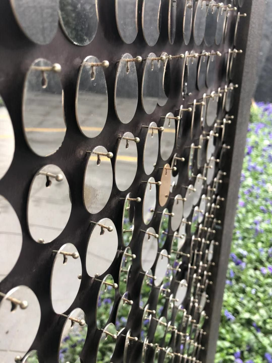 Decorative kinetic metal facade with wind-driven moving plates for landscape art